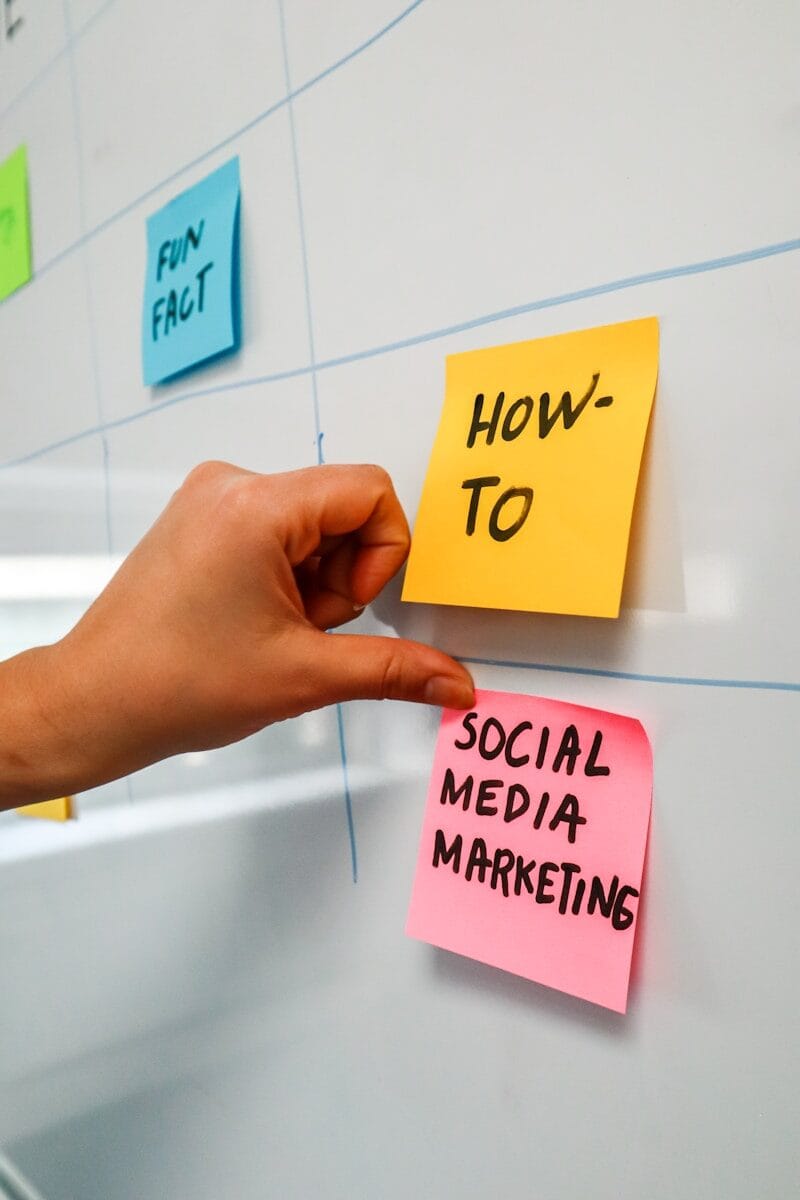 a hand is pointing to sticky notes on a bulletin board