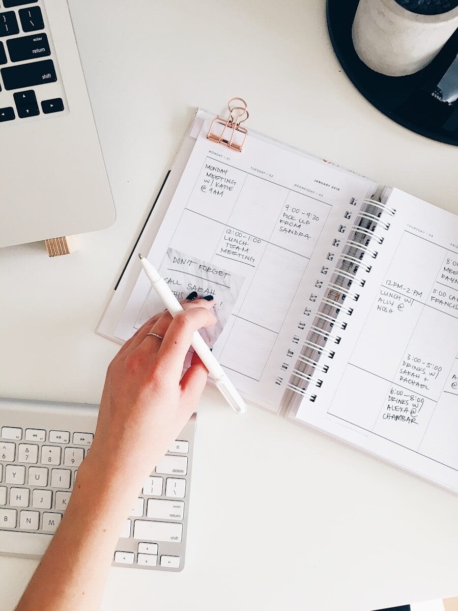 Best ADHD Planners & Apps for 2026 (Why Over-Complicated Apps Make You Freeze) 1 person holding notepad and pen flat lay photography